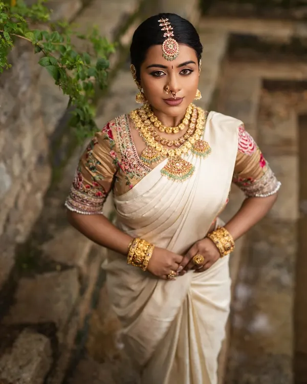 A goddess-like look created for a Varalakshmi festival shoot. The makeup is divine and regal, complementing the traditional white and gold saree.