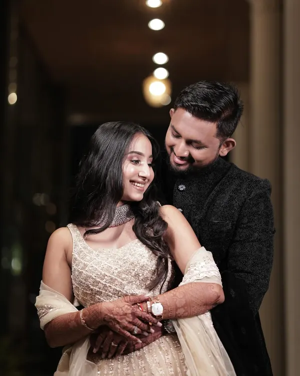 A beautiful, intimate moment from a pre-wedding photoshoot. The bride's makeup is soft and natural, with loose waves in her hair, creating a look of effortless romance.