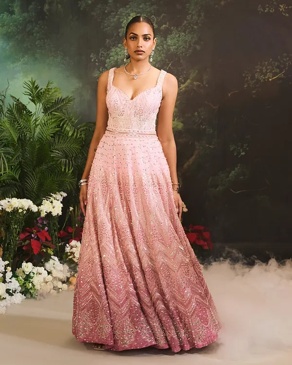The Celine Gown in a cascade of pink ombre tones. This floor-length gown is adorned with delicate, shimmering embellishments from top to bottom, creating a vision of pure luxury.