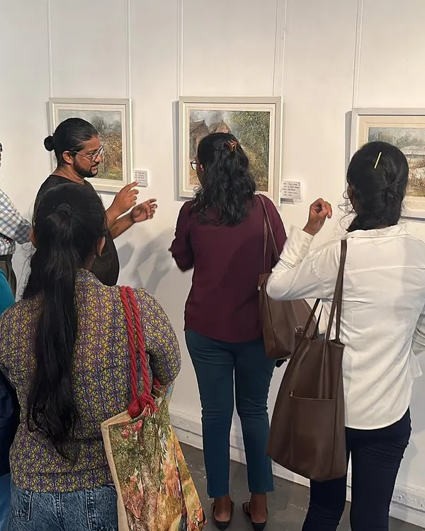 Visitors at my international exhibition in Colombo, looking closely at my watercolor paintings.