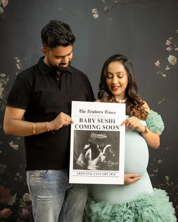 A perfect pregnancy announcement photo. The couple holds up a custom newspaper prop that reads "Baby Sushi Coming Soon," sharing their exciting news in a fun and creative way.