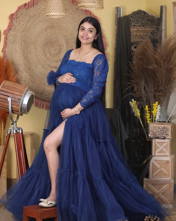 We love creating these glamorous portraits for moms-to-be. Here, our client is wearing a beautiful royal blue tulle gown from our studio wardrobe, posed against a rustic, warm-toned backdrop for a touch of drama and elegance.