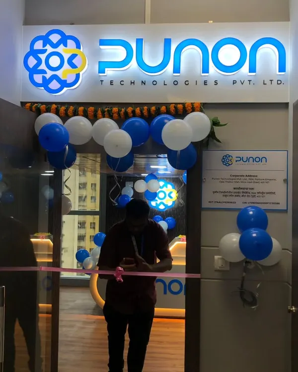 The entrance for the Punon Technologies office inauguration, featuring their illuminated brand logo, a traditional marigold garland, and a balloon arch in their corporate colors of blue and white.