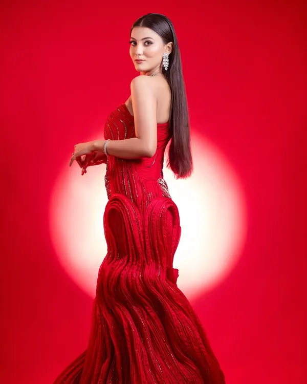 A striking editorial look designed to make a statement in any makeup portfolio. The model wears a structured red couture gown against a matching crimson backdrop with a dramatic spotlight, highlighting the sleek hair and flawless, high-fashion makeup. This demonstrates our ability to create bold, magazine-worthy images.