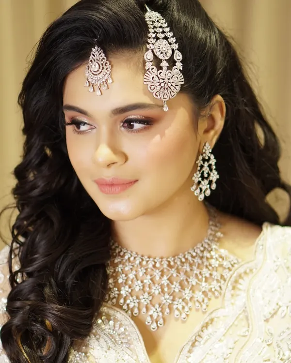 For this celebration, we focused on creating a look of pure grace and poise. The makeup features glowing skin, an ethereal shimmer on the eyes, and a soft lip color, all designed to complement her magnificent diamond jewelry.
