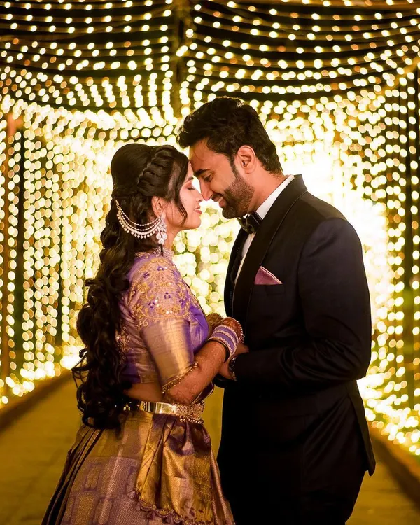 A magical moment for the couple, framed by a tunnel of fairy lights. We love creating these cinematic shots that feel like they are straight out of a movie, perfect for your reception or sangeet night.