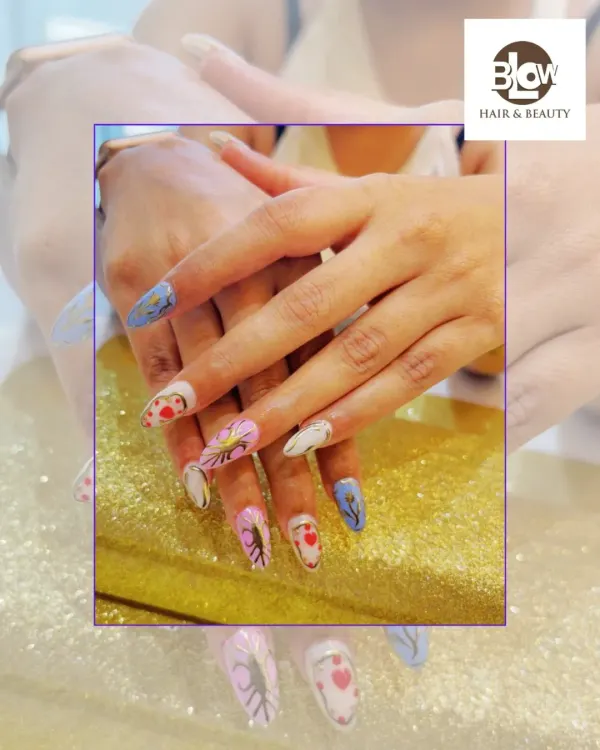 For the client who wants it all. This set features intricate, hand-painted nail art with a different design on each nail, including delicate leaves, hearts, and abstract patterns on a long stiletto shape.