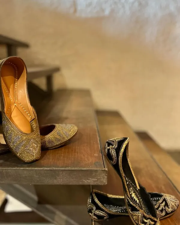 Because every outfit deserves the perfect pair. This image showcases two of my favorite juttis, one in shimmering gold and the other in classic black with gold embroidery.