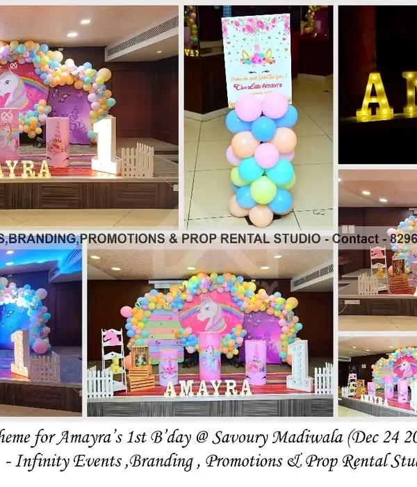 A magical unicorn theme for Amayra's first birthday. The setup features a circular backdrop with a unicorn illustration, a pastel rainbow balloon arch, and themed pedestals for a dreamy party.