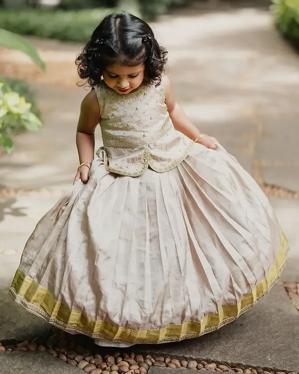 This little one is adorable in a custom pattu pavadai (traditional silk skirt and blouse). I designed this with a pleated skirt and a brocade peplum top for a classic yet comfortable fit.