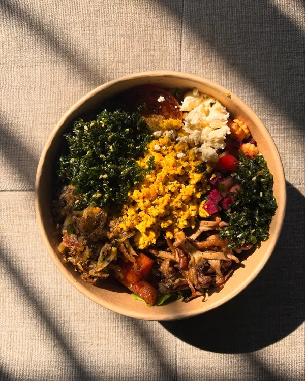 This is our idea of a perfect start to the day. The Breakfast Salad Bowl is a hearty mix of sweet potato roasti, scrambled tofu, crispy spinach, and feta, served with a light French vinaigrette.