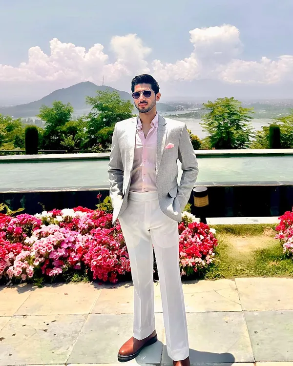 Our client Mr. Anand looking amazingly dapper in our creation. He wears a custom light grey blazer, pink shirt, and white trousers for a perfect summer formal look.