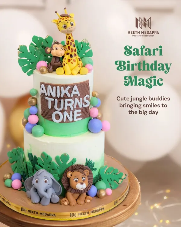 A full view of the two-tiered safari cake for Anika's first birthday, complete with a giraffe, monkey, lion, and elephant.