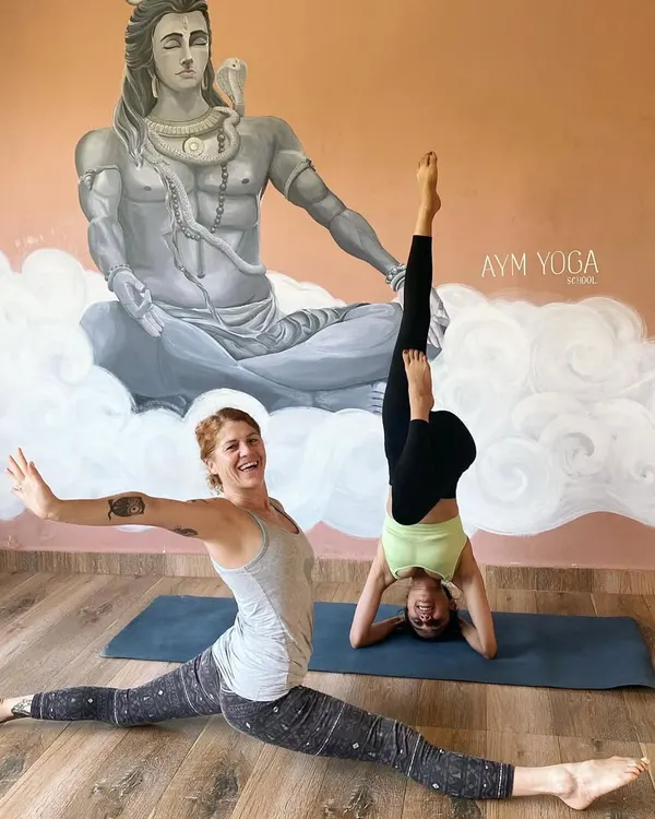 Celebrating International Yoga Day with a friend. Here I am in a variation of a supported headstand, a pose that strengthens the arms, shoulders, and core.
