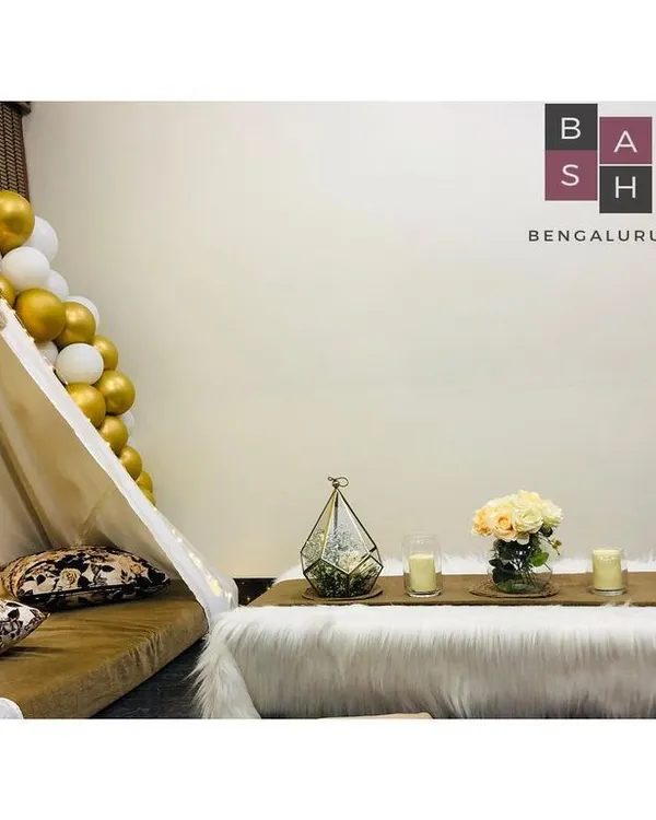 A full view of our chic and cozy boho tent setup, perfect for a surprise birthday or a romantic date night at home. The arrangement includes low seating on a plush rug, elegant table decor, and a beautiful gold and white balloon accent.