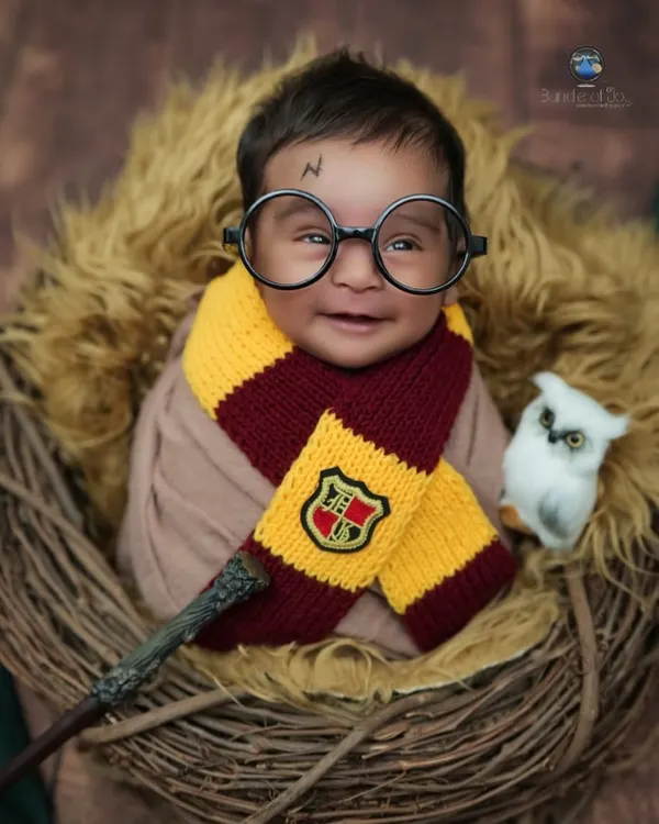 I believe in a little bit of magic, and this Harry Potter themed newborn session brings it to life. This shot shows a smiling baby wizard, complete with glasses and a Gryffindor scarf, ready for his own adventure.