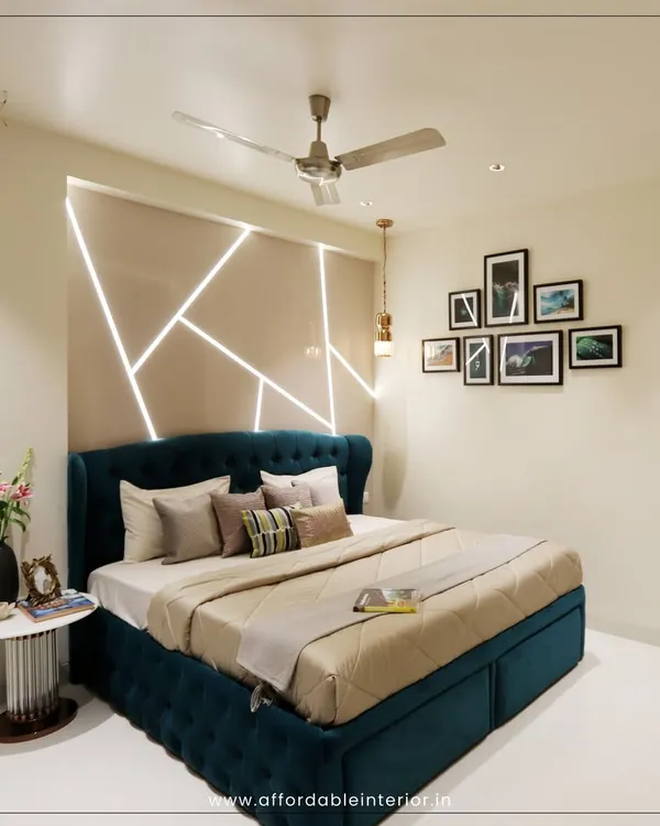 This modern bedroom design features a stunning accent wall with integrated geometric LED lighting behind a deep teal tufted bed, creating a dramatic and luxurious focal point.