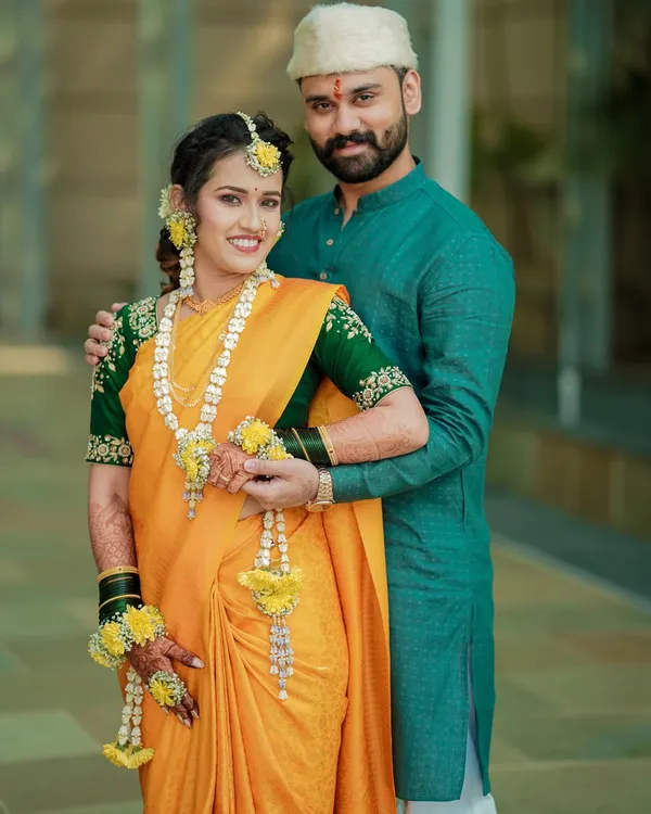 A classic portrait of a Maharashtrian couple during their pre-wedding rituals. The groom's protective embrace and the bride's happy smile tell a beautiful story.