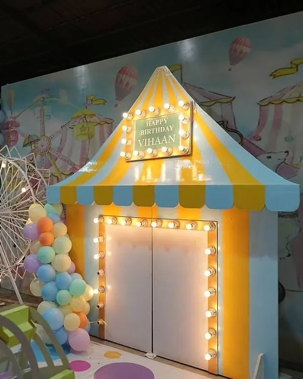 This grand entrance for Vihaan's pastel carnival party is one of my favorite setups. We built a full circus tent facade with classic marquee lights to welcome guests into a world of fun and wonder. It's all about creating that 'wow' moment from the second you arrive.