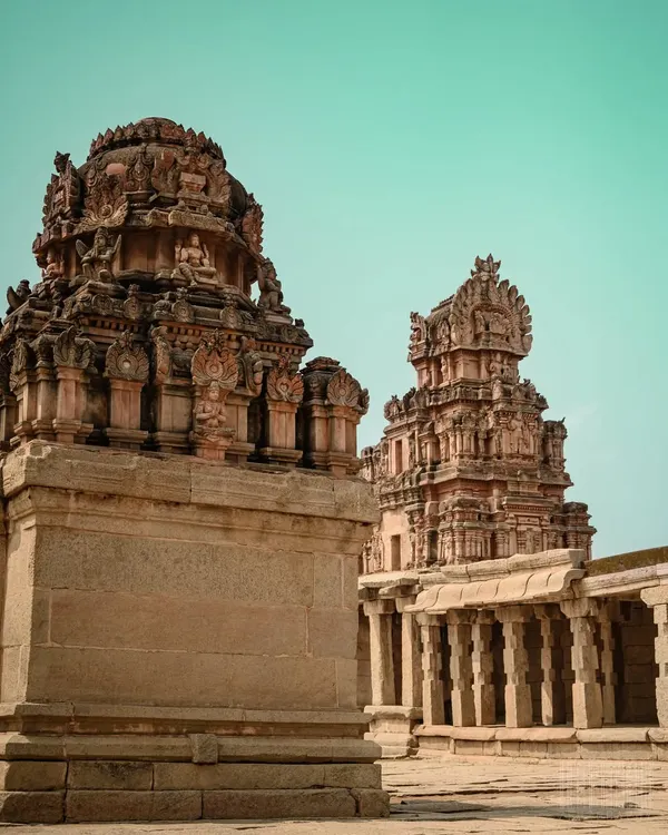 The majestic towers of the Virupaksha Temple in Hampi against a teal sky. My editing style brings a cinematic quality to architectural shots, highlighting their grandeur.