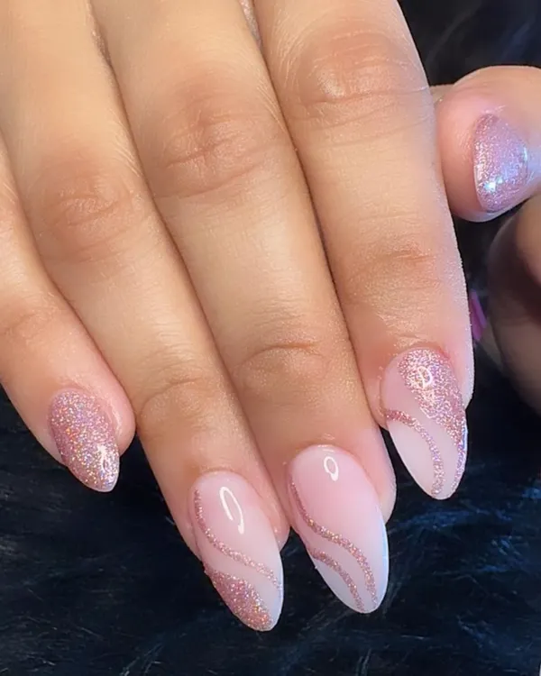 Pink glitter nails for the win! A beautiful combination of a sheer pink base with delicate rose gold glitter swirls.