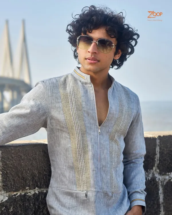 A sartorial choice for the discerning gentleman. This grey linen zip-up kurta, pictured against the Mumbai sea link, exemplifies a thoughtful blend of sophistication and comfort.