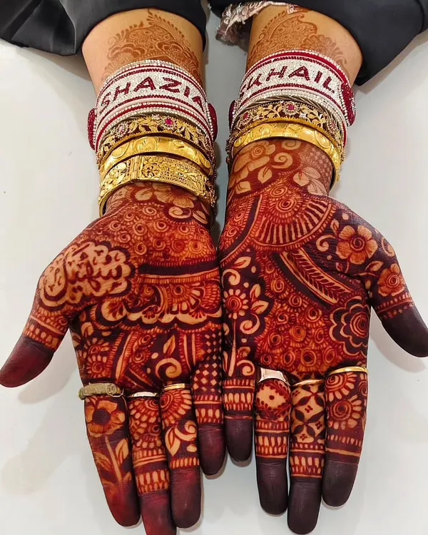The beautiful result of my organic henna paste. This deep, rich maroon stain is what every bride dreams of, shown here with traditional wedding bangles that have the couple's names, Shazia and Khail.