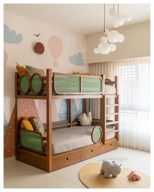 We designed this custom bunk bed with green rattan panels and built-in storage drawers. The whimsical wallpaper and cloud-shaped pendant lights make it a dream space for any child.