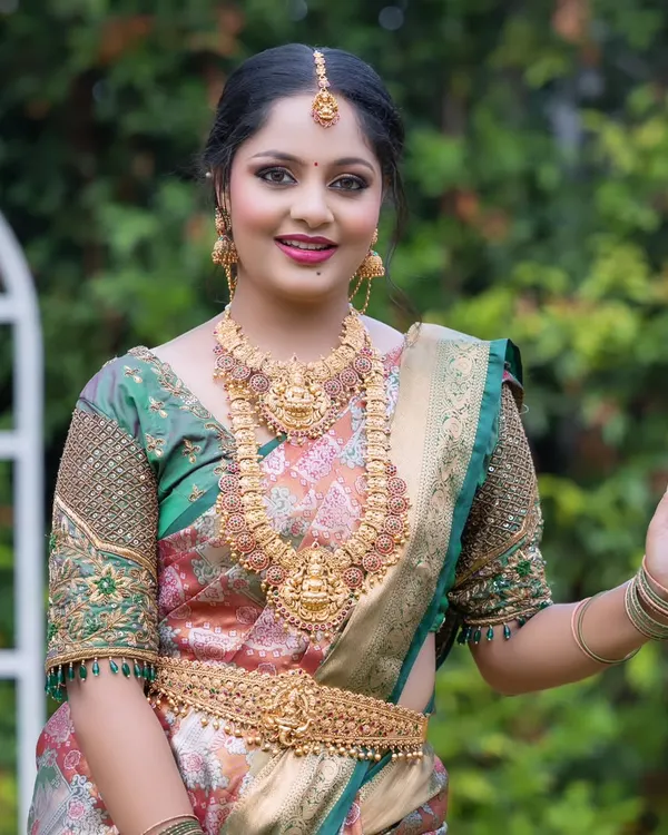 A happy bride wearing one of my classic temple jewellery sets. The set features a Lakshmi pendant haram and choker, perfect for a traditional South Indian wedding.