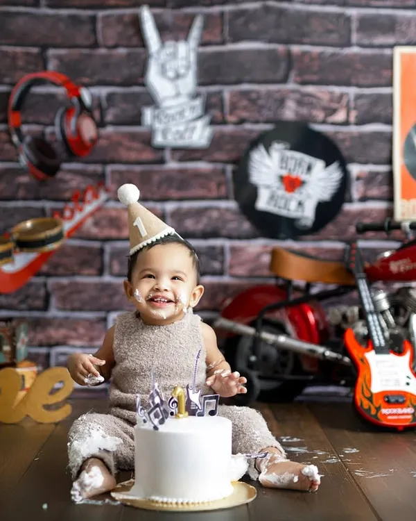 This little rockstar celebrating his first birthday is what pure joy looks like! A themed cake smash session is the perfect way to capture your baby's personality as they turn one.