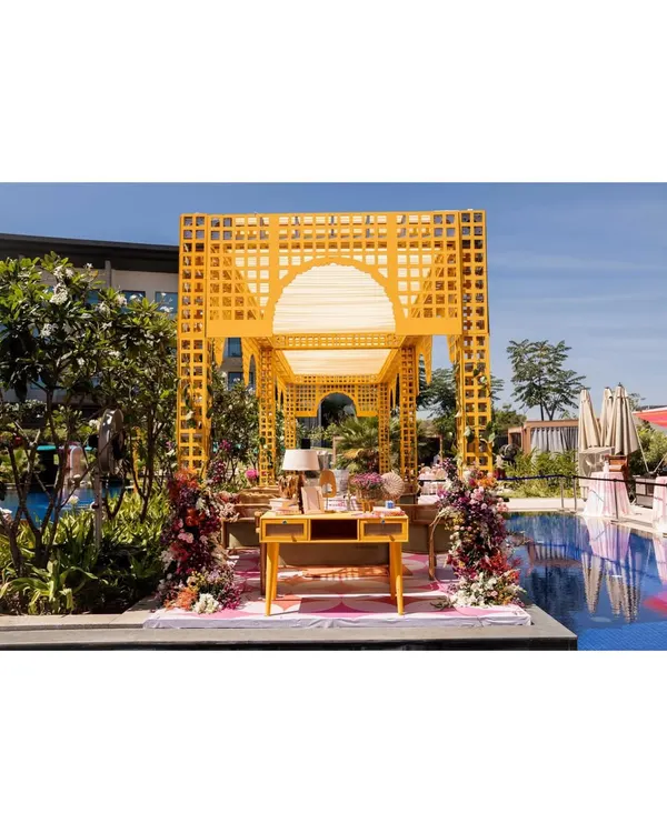 A stunning poolside Mehendi setup featuring a bright yellow trellis structure. This vibrant and sunny design is perfect for a sundowner event, creating a cheerful atmosphere for guests.