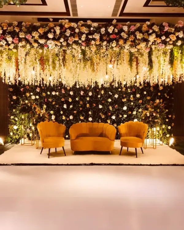 This is the hero item. I design breathtaking stages that become the heart of your celebration. This elegant reception setup features a lush floral arch and a cascading ceiling of white wisterias, creating a dreamy, romantic atmosphere for the perfect wedding photos.