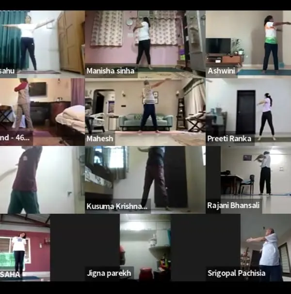 An early morning online session for International Yoga Day, with participants joining from their homes to practice together. This grid view shows the unity and discipline of our community, practicing arm stretches in sync under guided instruction.