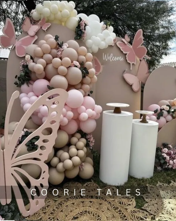 Your celebration can be as delicate and beautiful as a butterfly's wing. This outdoor setup features intricate, large-scale butterfly cutouts, a soft pink and neutral balloon arrangement, and floral accents for a truly enchanting experience.