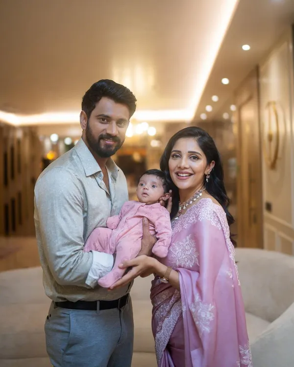 A beautiful family portrait of Milana, Krishna, and their newborn, with Milana wearing a custom Kalasthree saree for this precious moment.