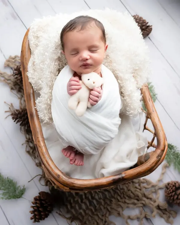 I just can't get enough of this little one. A simple, rustic setup with a cozy wrap and a soft teddy bear allows the baby's natural sweetness to shine through.