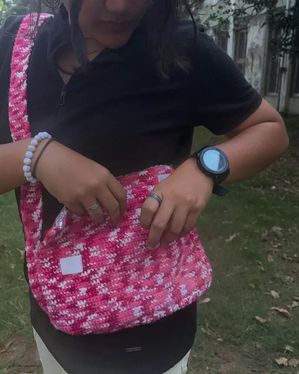 Showing how much the messenger bag can hold. It has a flap closure with a lace detail to keep everything safe inside.