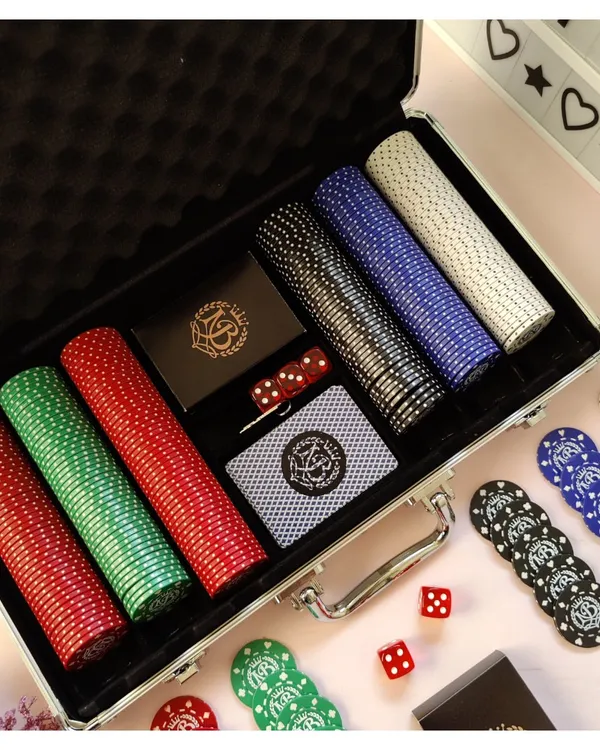 Make your game nights unforgettable with a personalized poker set. This image shows a complete set with custom-branded chips, cards, and dice, all neatly arranged in a professional aluminum carrying case.