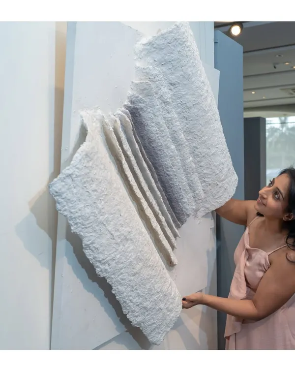 This piece is 'The Flight of Knowledge'. Its open-book form, crafted from upcycled paper, evokes the textures of lived experience, with each fold representing a chapter of learning.