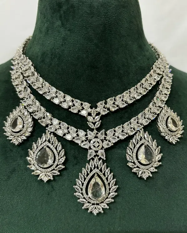 A stunning layered American diamond necklace set for rent. The brilliant-cut stones provide a dazzling look, and the set includes matching drop earrings.