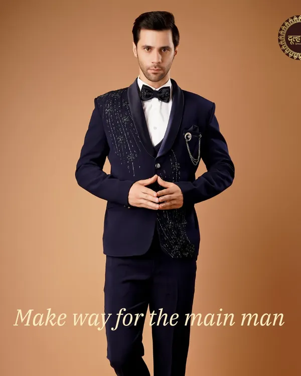 Make way for the main man. This deep navy tuxedo with an intricately embellished lapel is designed for the groom who owns the spotlight.