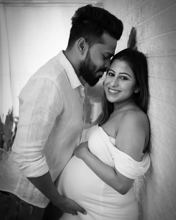 A classic and intimate black and white couple's portrait. The soft lighting and close framing emphasize the tender connection between the partners.