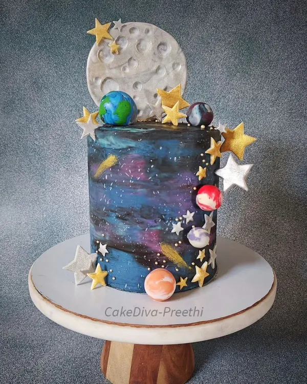 This 12-inch tall double barrel galaxy cake is one of my favorites. I used white chocolate ganache to paint a swirling galaxy effect, then decorated it with a fondant moon, stars, and planets for a truly out-of-this-world result.