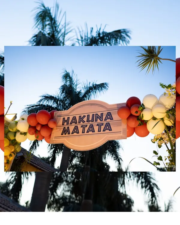 A "Hakuna Matata" sign framed by a sunset-colored balloon arch against a backdrop of palm trees perfectly captured the carefree spirit of The Lion King.