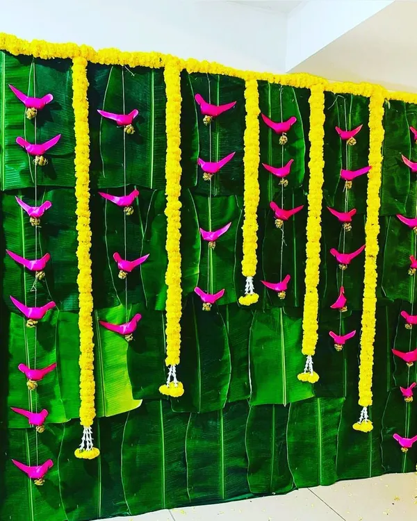 A completely natural and traditional backdrop made from fresh banana leaves, adorned with vertical garlands of yellow marigolds. This eco-friendly design is deeply rooted in South Indian wedding traditions.