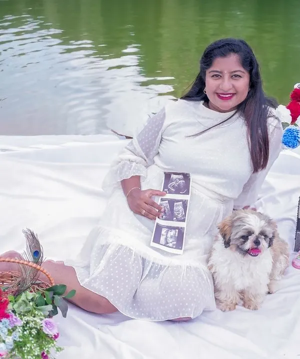 A sweet outdoor picnic setup by the water. Including the ultrasound scan pictures and the family pet makes this pregnancy announcement so personal.