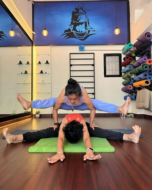 Welcome to my sacred space. Here, we support each other's growth, building strength and trust through practices like Acro Yoga, right under the gaze of Adiyogi. This is more than a class; it's a shared journey.
