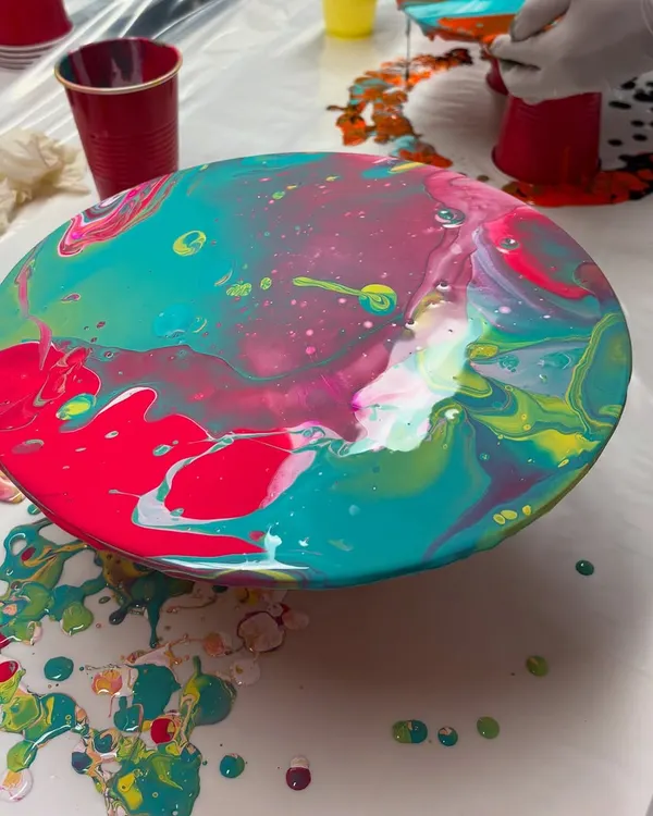 A finished fluid art piece on a round canvas, created during a Holi-themed workshop. The way the colors blend and create unique patterns is always mesmerizing.