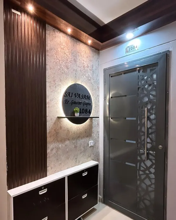 A well-designed entrance sets the tone for the entire home. This entrance features a backlit nameplate, a textured wall, and a sleek shoe cabinet, creating a warm and welcoming first impression.