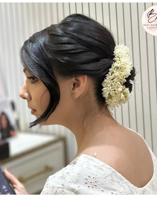 Elegance in a twist. This quick, sleek bun adorned with fresh flowers is classy, fierce, and forever sophisticated.